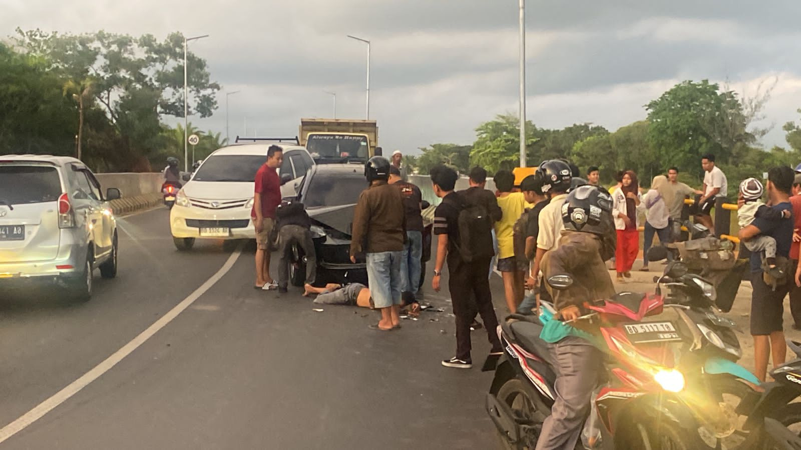 Adu Kambing Mini Bus vs Sepeda Motor di Jalan Jembatan Elevated, Satu Orang Terkapar 